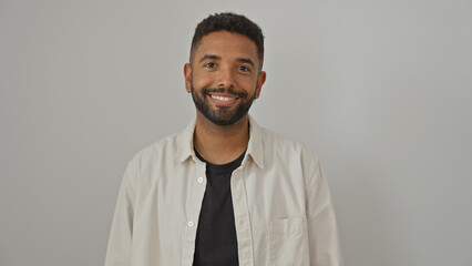 Smiling bearded young black man wearing casual clothes against a white background