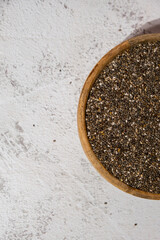 Chia seeds in wooden bowl. Healthy superfood rich in Omega 3 fatty acids. Dry healthy natural ingredient. Chia grains are falling