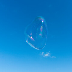 Eine riesige Seifenblase vor blauem Himmel