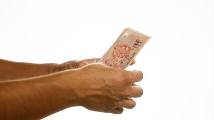Hands holding singaporean dollars over an isolated white background, emphasizing singapore currency