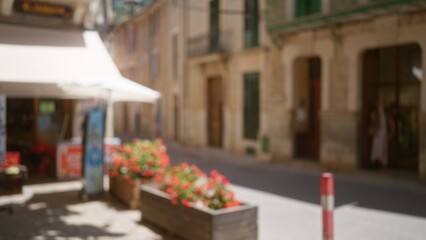 Blurred outdoor scene in mallorca with defocused flowers and bokeh effect on a sunny street