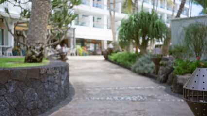 Blurred walkway in a tropical resort with lush greenery and modern architecture in the defocused background, capturing the serene vacation atmosphere