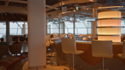 Blurred interior of a luxury restaurant with defocused chairs and modern lighting, featuring a relaxed atmosphere and stylish decor.