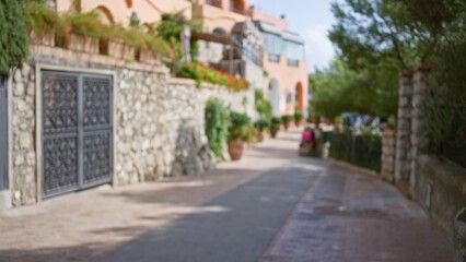 Blurred street scene with luxury vibe in capri, italy, featuring defocused architecture and plants along the stone path creating a serene atmosphere.