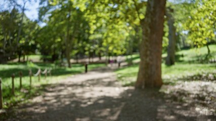 Blurry view of people walking in the sunlit villa borghese gardens in rome, showcasing green foliage and dappled light.