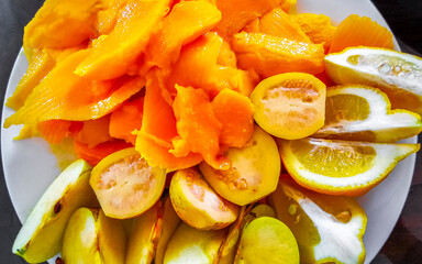 Meal in the restaurant white plate with tropical fruits.