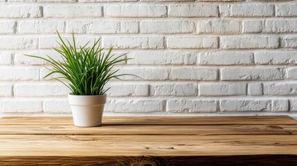 Wooden table featuring a houseplant in a flowerpot against a white brick wall backdrop High quality image