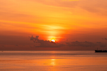 Scenic Golden Sunset over Calm Ocean with Silhouette of Ship