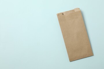 Craft paper bag on color background
