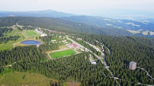 Aerial view of scenic tourist center and resort surrounded by lush forest and majestic mountains, Rogla, Slovenia.