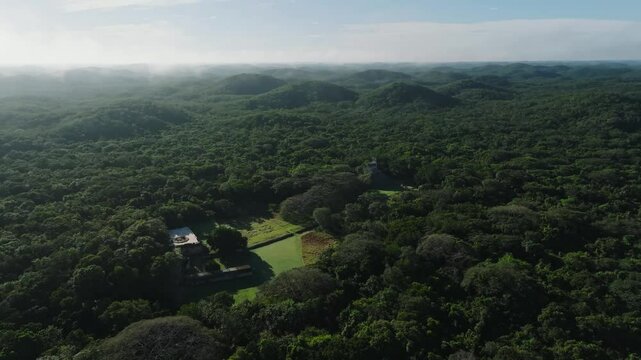 Aerial view of lush maya ruins surrounded by dense forest and hills, Labna, Yucatan, Mexico.