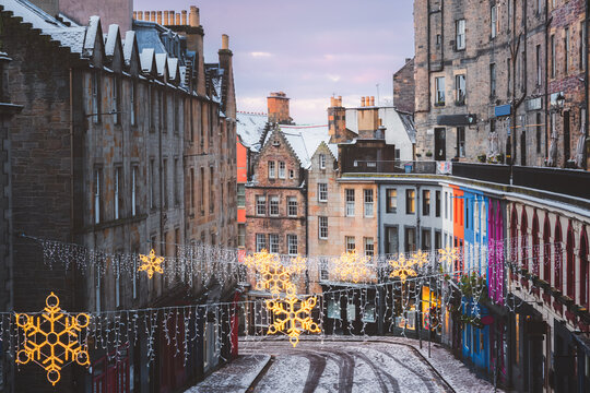 Victoria Street in Edinburgh adorned with festive Christmas lights and a fresh snowfall, capturing the charm of Scotland&rsquo;s winter season in the heart of the old town.