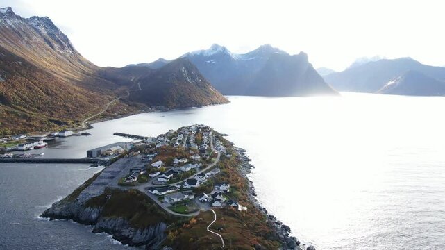 Aerial view of scenic village by the beautiful coast and rugged mountains at sunset, Lofoten Islands, Norway.
