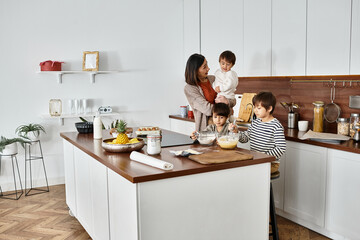 A happy grandmother shares a warm baking moment with her adorable grandsons in their cozy kitchen.