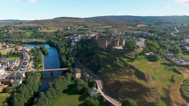 Aerial view of medieval castle and old town by the scenic Rio Tera river at sunset, Puebla de Sanabria, Spain.