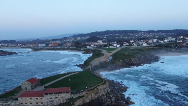 Aerial view of Ermida da Lanzada with beautiful coastline and waves, Sanxenxo, Spain.
