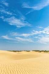 A serene desert landscape showcasing soft sand dunes under a bright blue sky with wispy clouds, creating a peaceful atmosphere.