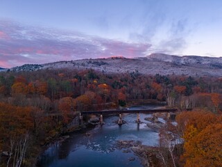 Scenic autumn landscape with river and bridge.