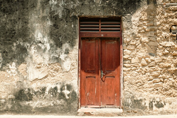A Swahili door or Zanzibar door on the entrance of the Old Fort - An abandoned historical building in Old Stone Town, Bagamoyo, Tanzania
