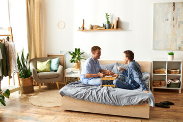 A gay couple shares a joyful morning together, enjoying breakfast while dressed in comfortable pajamas.