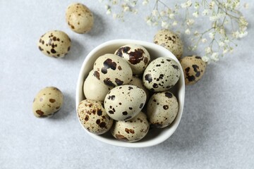 Quail eggs in a plate on gray background 
