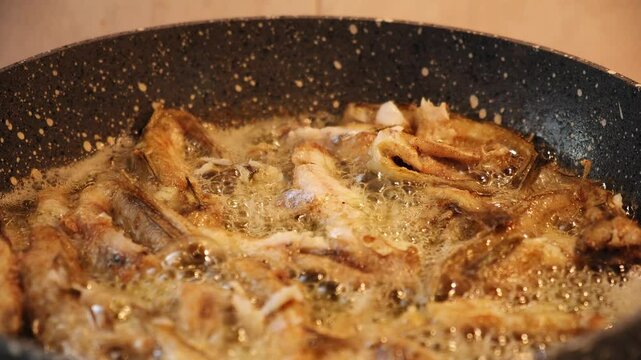 Frying the the black sea haddock fishes in a granite pan in 2x slow motion, zoom in
