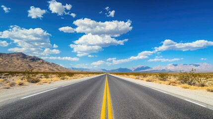 Naklejka premium Open asphalt highway under a stunning sky with mountains in the background