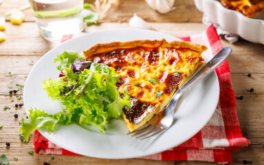 slice of quiche with salad on plate