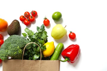 Paper bag, vegetables and fruits on white background