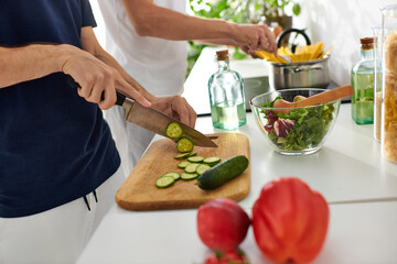 A loving gay couple prepares a vibrant salad in their modern kitchen