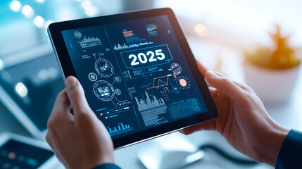 Close up of hands holding futuristic tablet displaying data visualizations for 2025, showcasing technology and innovation