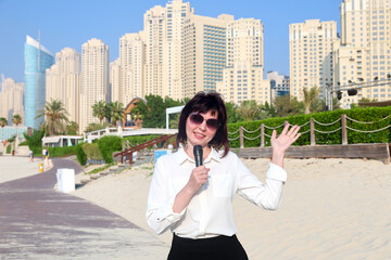 Fototapeta premium News anchor reports on resort town news from the beach.