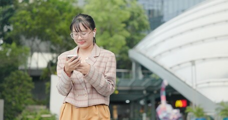 Fototapeta premium Asian teenage woman using smartphone to shop online. Women make financial transactions, transfer money via bank apps, order products. Businesswoman chatting on mobile phone. communication technology