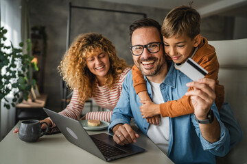 family of 3 have online shopping on laptop with credit card