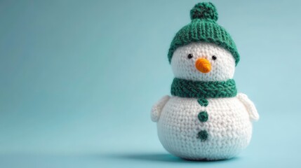 A cute crocheted snowman wearing a green hat and scarf, perfect for winter decor.