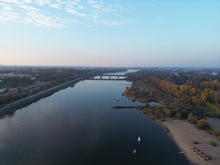 Autumn Landscape of River with Boats and City on Horizon on a Quiet Day