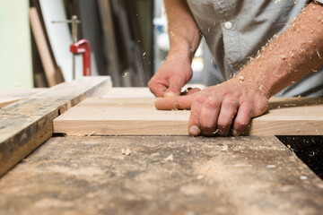 A carpenter is milling an oak part on a homemade machine