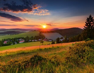 Obraz premium Picturesque sunset in Beskid Sądecki seen from the tower in Wola Krogulecka, with views of the mountains and fields.