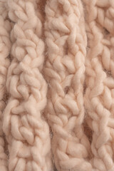 A fragment of beige knitted fabric, knitted from white sheep wool.