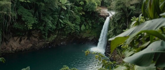 A majestic waterfall cascades into a serene azure pool, carved naturally into verdant cliffs, offering a tranquil escape from the world.
