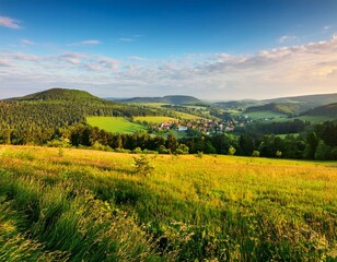 Fototapeta premium A beautiful green mountainous landscape with many trees under a bright sky