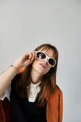 Sporting fashionable clothing and sunglasses, the young man exudes a cool vibe in a stylish setting.