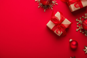 Merry Christmas and Happy Holidays greeting card, frame, banner. New Year. Noel. Red Christmas ornaments and gifts, presents on red background top view. Winter xmas holiday theme. Flat lay	