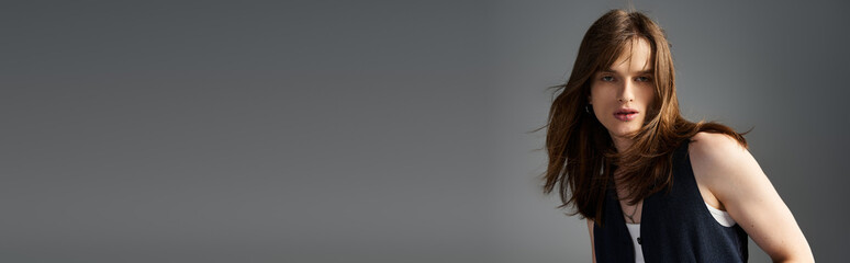 A young fashionable guy confidently displays trendy attire in a modern city environment.