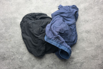 Blue and black torn underwear pants from a long time wearing. Everyday wearing. Old and torn underwear needs to be repaired or changed.