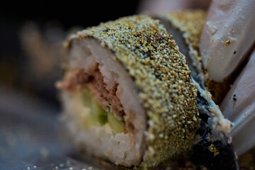 Chef slicing sushi roll with sharp knife