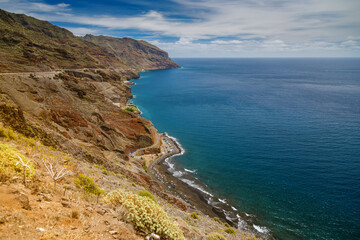 Fototapeta premium Aerial view of Tenerife’s Playa de las Gaviotas displaying striking contrasts with dark sands, rocky cliffs, and a turquoise ocean
