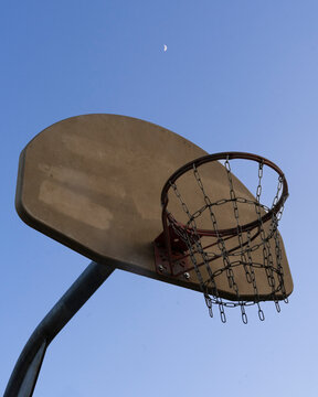 View of basketball hoop under the moon with a blue sky backdrop, Fort Worth, United States of America.