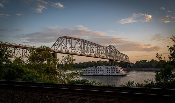 View of a serene sunset over the Mississippi River with a bridge and a boat, Chester, United States.