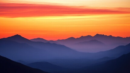 Serene sunset sky in shades of orange and pink featuring silhouetted mountains below perfect as a backdrop for subjects placed in the foreground